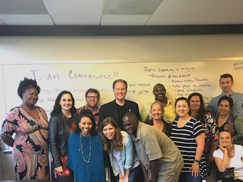 A group of CSH team members smiling in front of a white board