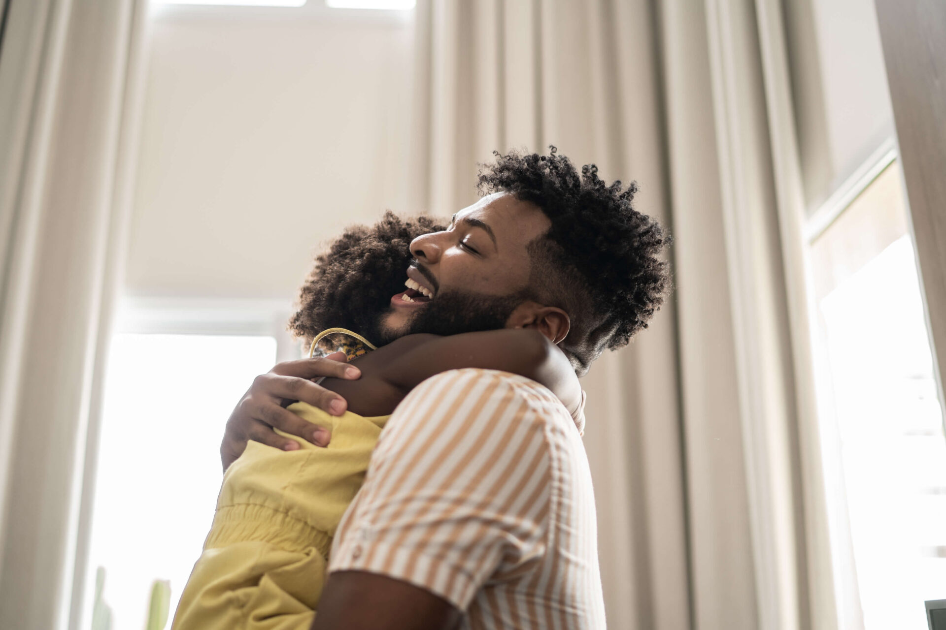 This is a photo of a man smiling as he embraces his daughter.