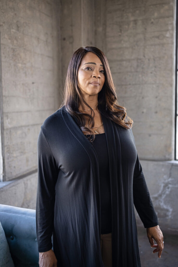 woman wearing black cardigan standing in front of building
